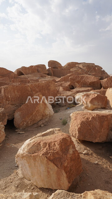 منظر الغيوم والسحب البيضاء في السماء، جبل القارة في النهار، القمم والمرتفعات الجبلية في مدينة الاحساء، المعالم التاريخية الأثرية القديمة في المملكة العربية السعودية، التضاريس الطبيعية والتكوينات والتشكلات الصخرية