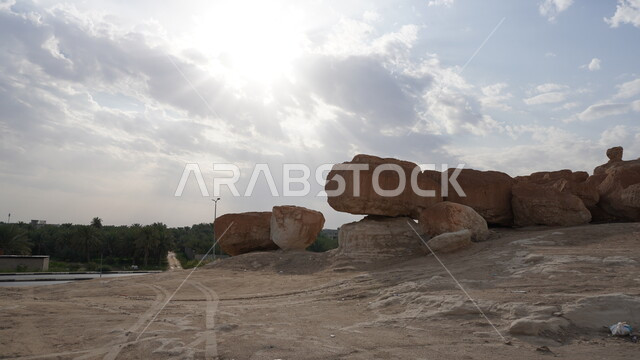 جبل القارة في النهار، منظر الغيوم والسحب البيضاء في السماء، القمم والمرتفعات الجبلية في مدينة الاحساء، المعالم التاريخية الأثرية القديمة في المملكة العربية السعودية، التضاريس الطبيعية والتكوينات والتشكلات الصخرية