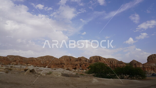 منظر الغيوم والسحب البيضاء في السماء، جبل القارة في النهار، القمم والمرتفعات الجبلية في مدينة الاحساء، المعالم التاريخية الأثرية القديمة في المملكة العربية السعودية، التضاريس الطبيعية والتكوينات والتشكلات الصخرية