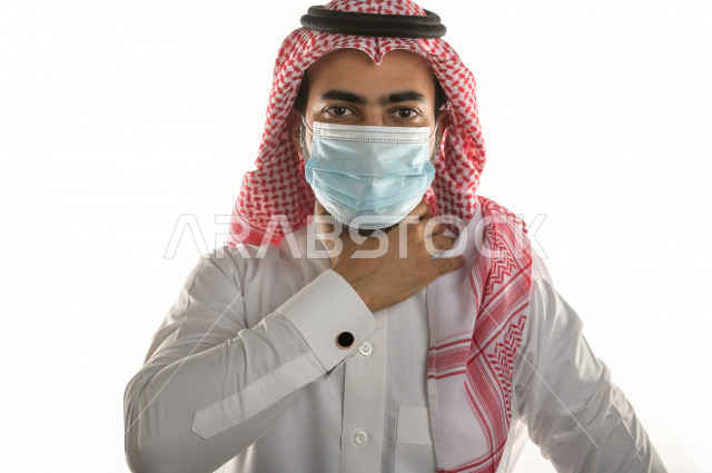 بورتريه لرجل سعودي خليجي غاضب و عابس   يرتدي الكمامة ، بإيماءات  يدين مختلفة  ، حركات يدين مختلفة ، خلفية بيضاء