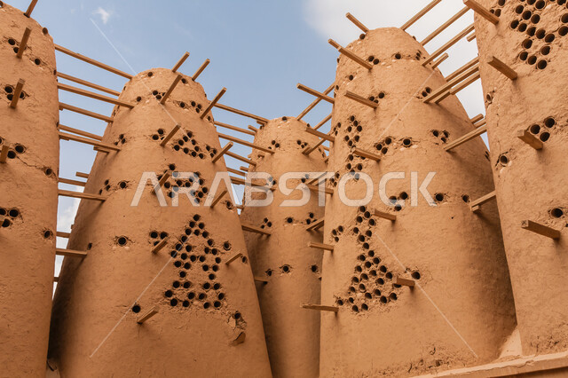 Historical monuments, tourist places in Saudi Arabia, the architectural art of ancient mud buildings for raising pigeons, a close-up of pigeon towers in the desert areas in the Dalam Governorate in the city of Riyadh, mountain peaks and heights.