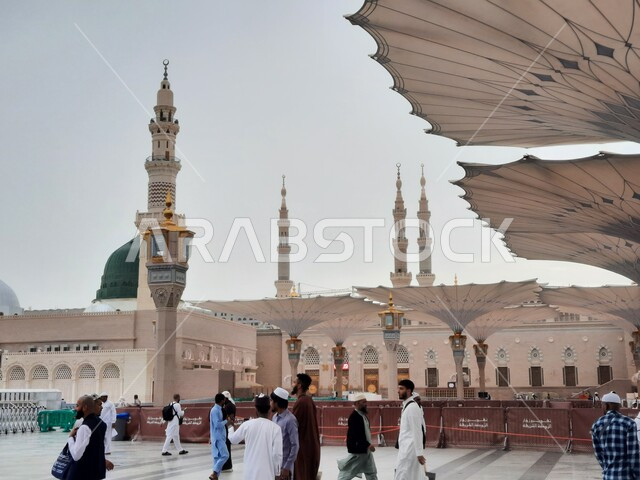 المعالم الاسلامية المقدسة, قدوم الناس من شتى أنحاء العالم لأداء العبادات والفرائض, تجمع المسلمين في الساحة الخارجية للمسجد النبوي الشريف في المدينة المنورة, أماكن دينية وأجواء روحانية, المآذن والقبب والمظلات الالكترونية الحديثة