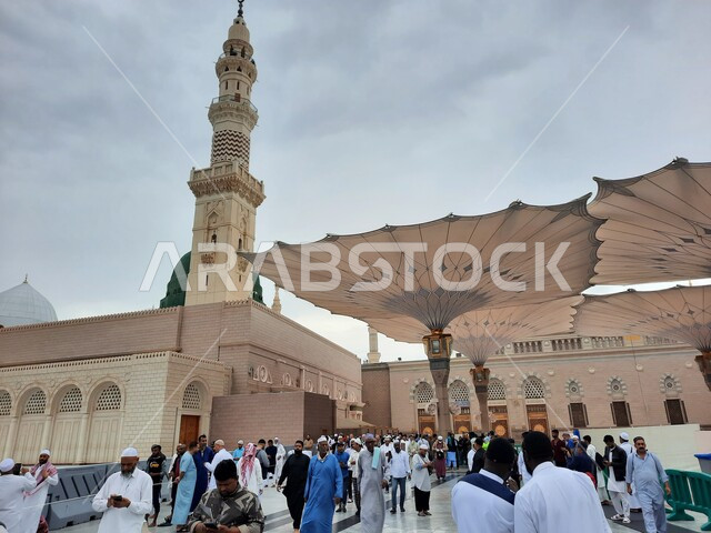  أماكن دينية وأجواء روحانية, المعالم الاسلامية المقدسة, قدوم الناس من شتى أنحاء العالم لأداء العبادات والفرائض, تجمع المسلمين في الساحة الخارجية للمسجد النبوي الشريف في المدينة المنورة, المآذن والقبب والمظلات الالكترونية الحديثة