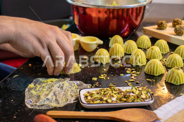  استخدام القوالب لتشكيل أقراص المعمول، طريقة إعداد وتحضير الحلويات الشهية، الاستعداد لاستقبال الأعياد والمناسبات الإسلامية السعيدة، قطع معمول العيد الشهية، كرم الضيافة وحسن الاستقبال في السعودية, منتجات محلية وطنية، حلى سعودي بالعجوة والمكسرات