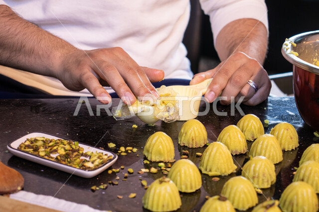  استخدام القوالب لتشكيل أقراص المعمول، طريقة إعداد وتحضير الحلويات الشهية، الاستعداد لاستقبال الأعياد والمناسبات الإسلامية السعيدة، قطع معمول العيد الشهية، كرم الضيافة وحسن الاستقبال في السعودية, منتجات محلية وطنية، حلى سعودي بالعجوة والمكسرات