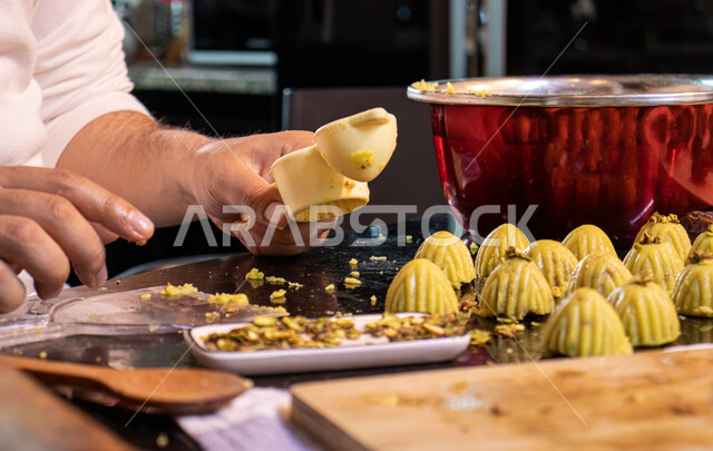  استخدام القوالب لتشكيل أقراص المعمول، طريقة إعداد وتحضير الحلويات الشهية، الاستعداد لاستقبال الأعياد والمناسبات الإسلامية السعيدة، قطع معمول العيد الشهية، كرم الضيافة وحسن الاستقبال في السعودية, منتجات محلية وطنية، حلى سعودي بالعجوة والمكسرات