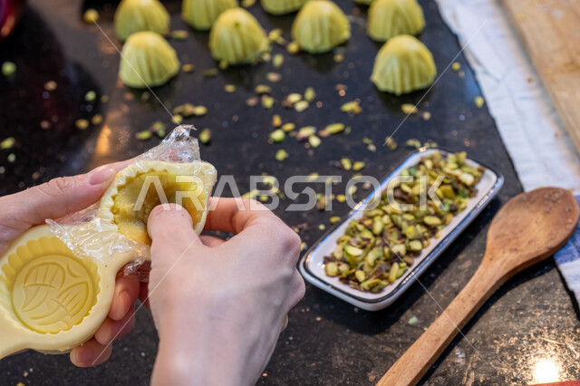  استخدام القوالب لتشكيل أقراص المعمول، طريقة إعداد وتحضير الحلويات الشهية، الاستعداد لاستقبال الأعياد والمناسبات الإسلامية السعيدة، قطع معمول العيد الشهية، كرم الضيافة وحسن الاستقبال في السعودية, منتجات محلية وطنية، حلى سعودي بالعجوة والمكسرات