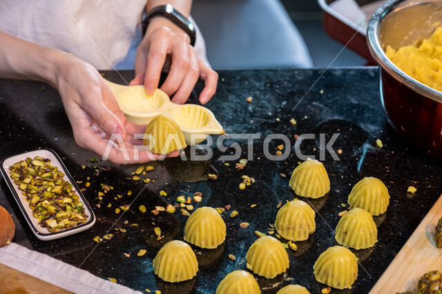  استخدام القوالب لتشكيل أقراص المعمول، طريقة إعداد وتحضير الحلويات الشهية، الاستعداد لاستقبال الأعياد والمناسبات الإسلامية السعيدة، قطع معمول العيد الشهية، كرم الضيافة وحسن الاستقبال في السعودية, منتجات محلية وطنية، حلى سعودي بالعجوة والمكسرات