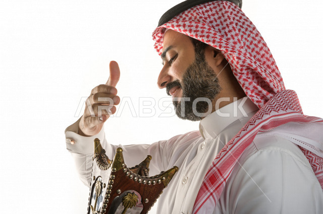 بورتريه لرجل عربي سعودي  يحمل حامل البخور( المبخرة ) ، استخدام خشب العود في المناسبات الاجتماعية و المناسبات الدينية ،  اصالة العادات و التقاليد في المملكة العربية السعودية ، التطيب و التعطر