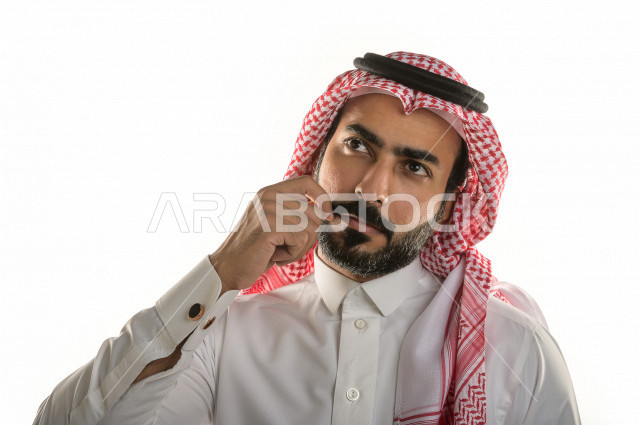 بورتريه لرجل سعودي خليجي بإيماءات الوجه تدل على التفكير و التركيز، خلفية بيضاء