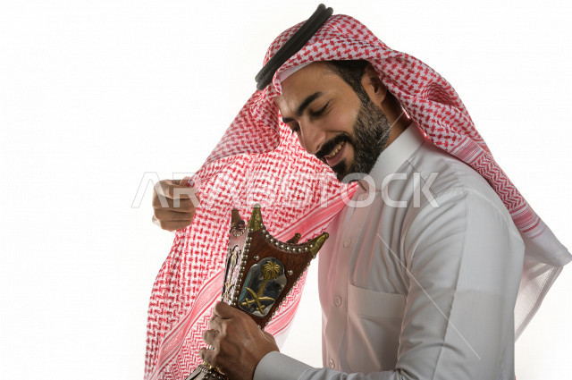 بورتريه لرجل عربي سعودي  يحمل حامل البخور( المبخرة ) ، استخدام خشب العود في المناسبات الاجتماعية و المناسبات الدينية ،  اصالة العادات و التقاليد في المملكة العربية السعودية ، التطيب و التعطر