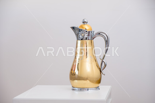 Decorative golden copper Arabic coffee dallah, antique antiques of ancient style, popular customs and traditions in the Kingdom of Saudi Arabia, warm hospitality and warm reception, white background