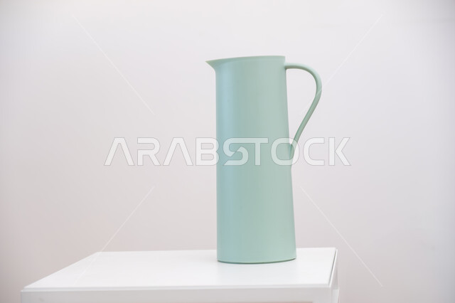 The concept of hospitality and good reception, Arabic coffee dallah on the table, popular customs and traditions in the Kingdom of Saudi Arabia, white background