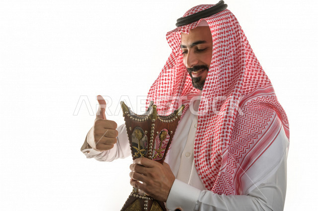 بورتريه لرجل عربي سعودي  يحمل حامل البخور( المبخرة ) ، استخدام خشب العود في المناسبات الاجتماعية و المناسبات الدينية ،  اصالة العادات و التقاليد في المملكة العربية السعودية ، التطيب و التعطر