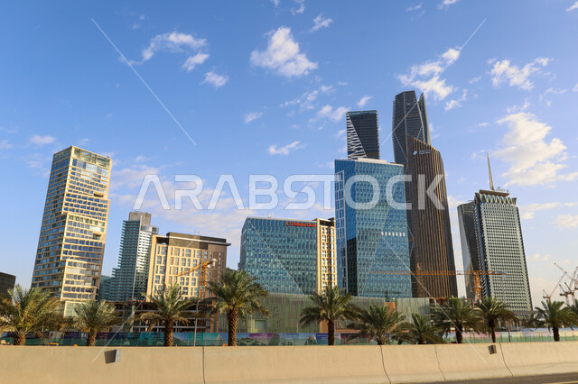 The architectural engineering art of the economic towers and skyscrapers in the Kingdom of Saudi Arabia, the famous landmarks of Riyadh, urban growth and progress in the modern style, interest in afforestation and planting palm trees, the King Abdullah Financial Center in the city of Riyadh by day