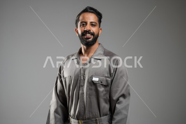 Gestures of happiness and pleasure, close-up portrait of a smiling Saudi Arabian Gulf maintenance worker looking at the camera, skill and workmanship, gray background, sensitive content, sensitive use