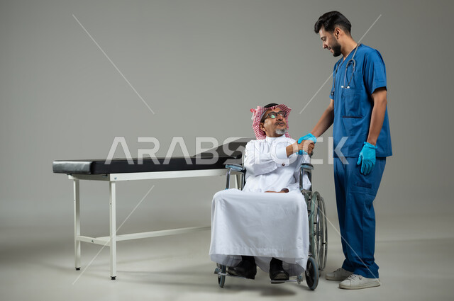 شكر وتقدير الطبيب لجهوده ورعايته الطبية، تقديم أفضل الخدمات الصحية لمرضى كبار السن في المستشفى، بورتريه لرجل عربي خليجي سعودي يرتدي الزي التقليدي والشماغ يجلس على الكرسي المتحرك يصافح الممرض ، صورة الجسم بالطول الكامل، خلفية رمادية، محتوى حساس ، استخدام حساس