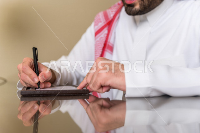 رجل خليجي سعودي يسافر بداعي العمل وينزل في أحد الفنادق , رجل أعمال خليجي يحمل معه حقيبة السفر و الأجهزة الذكية للعمل في الفندق , سياحة وسفر  , حب الاستطلاع والشغف في العمل . 