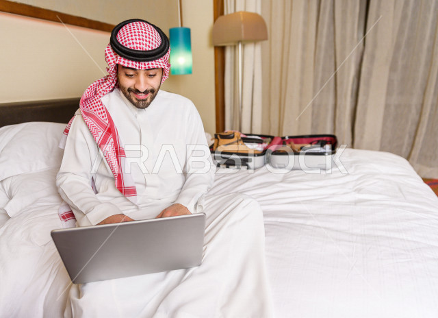 رجل خليجي سعودي يسافر بداعي العمل وينزل في أحد الفنادق , رجل أعمال خليجي يحمل معه حقيبة السفر و الأجهزة الذكية للعمل في الفندق , سياحة وسفر  , حب الاستطلاع والشغف في العمل . 