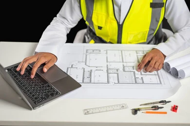 Working in the engineering sector, the concept of project management and auditing, a close-up portrait of a Saudi Gulf Arab engineer wearing a traditional dress and a protective jacket sitting behind the desk following up on work and project plans, black background, sensitive content, sensitive use