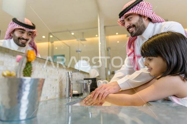 أب عربي سعودي يعلم إبنته كيفية غسل اليدين جيدا بالصابون للحماية من فايروس كورونا , اتباع الإجراءات الوقائية للحماية من الجراثيم والميكروبات والفايروسات , النظافة من الإيمان لا تهدر في الماء , الوضوء ,لا للإسراف في استخدام الماء . 