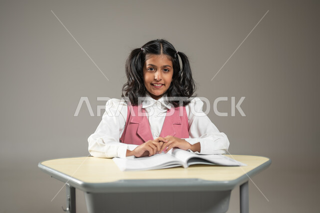 تطور التعليم في المملكة العربية السعودية, طرائق تدريس جديدة ومبتكرة, التعلم الفعال والمشاركة مع الطلاب, بورتريه لتلميذة عربية خليجية سعودية, دروس و واجبات منزلية, خلفية رمادية, محتوى حساس