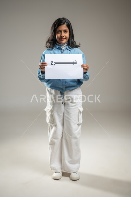 Encouraging donations to the poor and needy, launching awareness campaigns in society about the importance of helping the poor, portrait of a Saudi Gulf Arab girl holding a white board with a donation written on it, gestures of joy and pleasure, full-length body, gray background, sensitive content, sensitive use