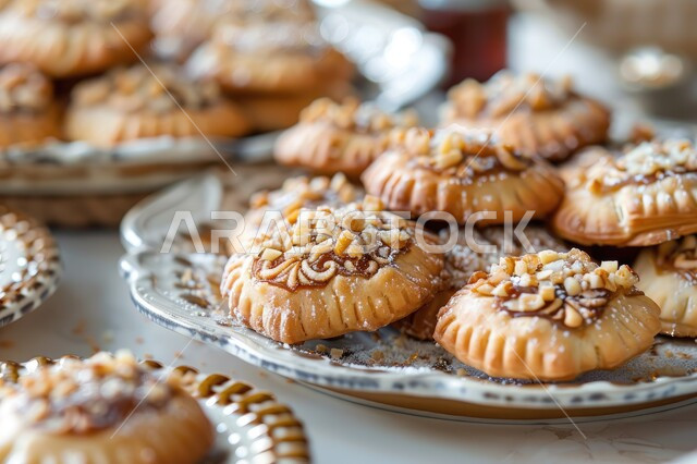 الاستعداد لاستقبال الأعياد والمناسبات الإسلامية السعيدة، أقراص المعمول المزينة بالفستق، حلى سعودي بالمكسرات، طريقة إعداد وتحضير الحلويات الشهية، قطع حلوى العيد الشهية، كرم الضيافة وحسن الاستقبال في السعودية