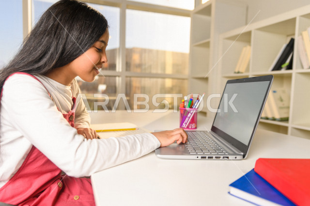 تلميذة سعودية خليجية تدرس في المنزل وتستخدم الحاسوب المحمول  ،الدراسة من خلال منصة تعليمية للتعلم عن بعد ، تأدية الواجبات المدرسية ، التعلم عن بعد ، مفهوم التعليم عبر الانترنت ، التعليم المنزلي ، العزلة الذاتية .