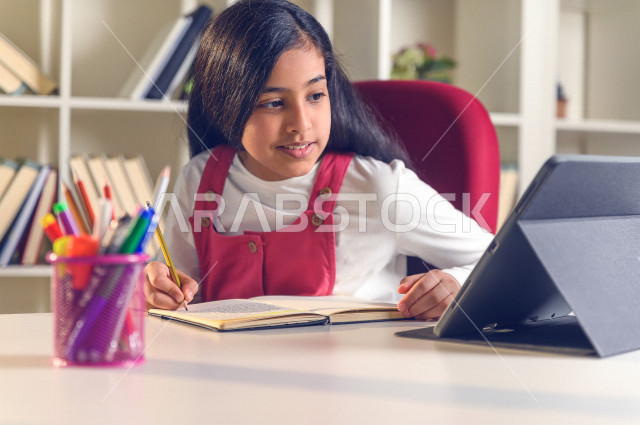 تلميذة سعودية خليجية تدرس في المنزل ،الدراسة من خلال منصة تعليمية للتعلم عن بعد ، تأدية الواجبات المدرسية ، التعلم عن بعد ، مفهوم التعليم عبر الانترنت ، التعليم المنزلي ، العزلة الذاتية .