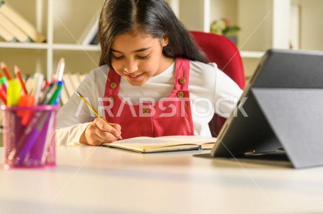 تلميذة سعودية خليجية تدرس في المنزل ،الدراسة من خلال منصة تعليمية للتعلم عن بعد ، تأدية الواجبات المدرسية ، التعلم عن بعد ، مفهوم التعليم عبر الانترنت ، التعليم المنزلي ، العزلة الذاتية .