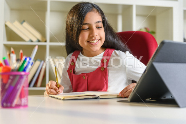 تلميذة سعودية خليجية تدرس في المنزل ،الدراسة من خلال منصة تعليمية للتعلم عن بعد ، تأدية الواجبات المدرسية ، التعلم عن بعد ، مفهوم التعليم عبر الانترنت ، التعليم المنزلي ، العزلة الذاتية .