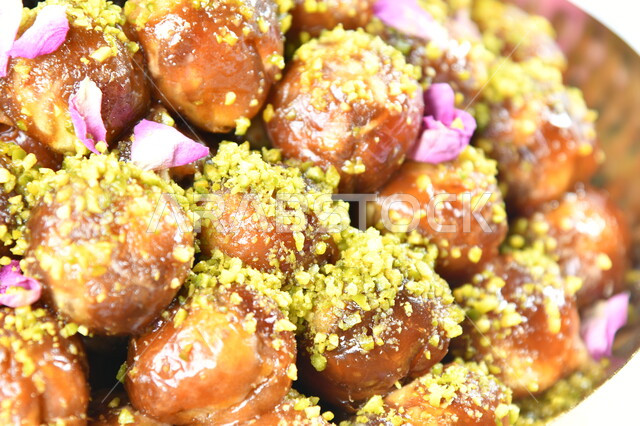 حلويات عربية شعبية، صورة مقربة لطبق من اللقيمات الشهية، مأكولات ذات سعرات حرارية عالية، مطاعم للمأكولات العربية الشرقية، الأساليب الفنية في تقديم الطعام