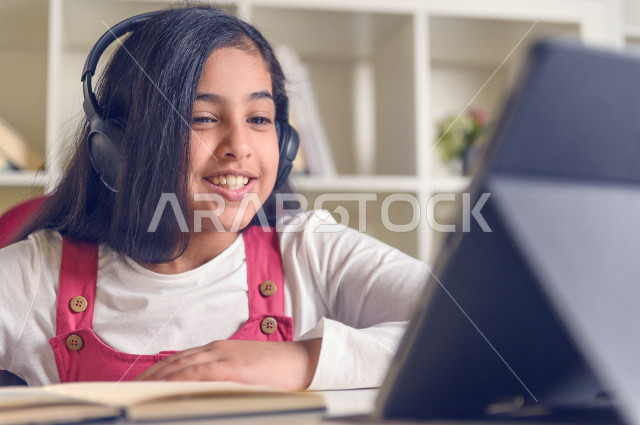 تلميذة سعودية خليجية تدرس في المنزل ،الدراسة من خلال منصة تعليمية للتعلم عن بعد ، تأدية الواجبات المدرسية ، التعلم عن بعد ، مفهوم التعليم عبر الانترنت ، التعليم المنزلي ، العزلة الذاتية .