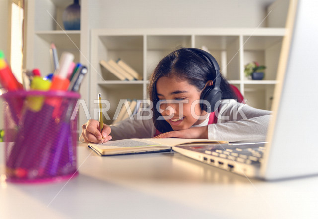 تلميذة سعودية خليجية تدرس في المنزل ،الدراسة من خلال منصة تعليمية للتعلم عن بعد ، تأدية الواجبات المدرسية ، التعلم عن بعد ، مفهوم التعليم عبر الانترنت ، التعليم المنزلي ، العزلة الذاتية .