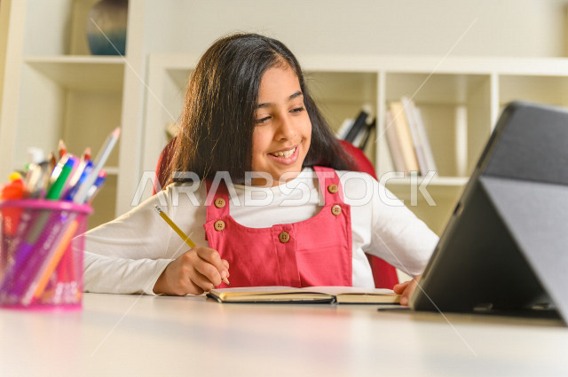 تلميذة سعودية خليجية تدرس في المنزل ،الدراسة من خلال منصة تعليمية للتعلم عن بعد ، تأدية الواجبات المدرسية ، التعلم عن بعد ، مفهوم التعليم عبر الانترنت ، التعليم المنزلي ، العزلة الذاتية .