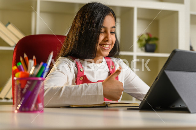 تلميذة سعودية خليجية تدرس في المنزل ،الدراسة من خلال منصة تعليمية للتعلم عن بعد ، تأدية الواجبات المدرسية ، التعلم عن بعد ، مفهوم التعليم عبر الانترنت ، التعليم المنزلي ، العزلة الذاتية .