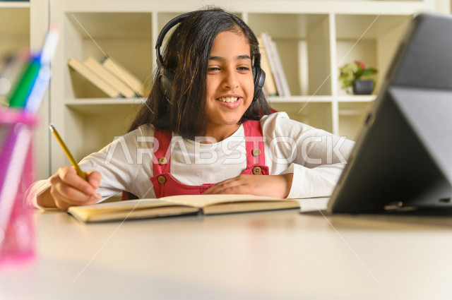 تلميذة سعودية خليجية تدرس في المنزل ،الدراسة من خلال منصة تعليمية للتعلم عن بعد ، تأدية الواجبات المدرسية ، التعلم عن بعد ، مفهوم التعليم عبر الانترنت ، التعليم المنزلي ، العزلة الذاتية .