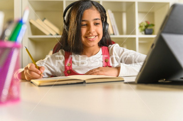 A Saudi Arabian student studying at home, studying through an educational platform for distance learning, doing homework, distance learning, the concept of online education, home education, self-isolation