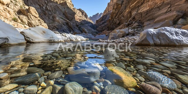جريان المياه الصافية في وادي بين سلسلة الجبال والتكوينات والتشكلات الصخرية في المناطق الصحراوية، الوديان والقمم الصخرية في البراري، اماكن سياحية مشهورة في المملكة العربية السعودية