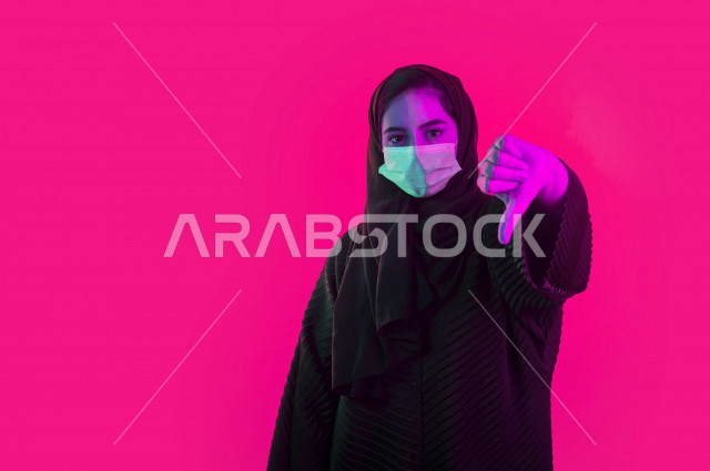 بورتريه لشابة سعودية تقوم ترتدي الكمامة لتجنب تفشي الفايروس ، ايماءات و حركات يدين تدل على الحذر ،  اتباع اجراءات السلامة ، تجنب انتشار العدوى ، خلفية ملونة