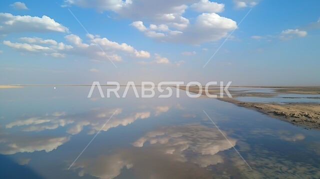 انعكاس الغيوم البيضاء على صفحة مياه البحيرة، البحيرات المائية في المناطق الصحراوية، المحميات الطبيعية في المملكة العربية السعودية، التلال والكثبان الرملية الناعمة في الصحراء، مناطق رحلات السفاري الترفيهية، منظر السحب في السماء الزرقاء