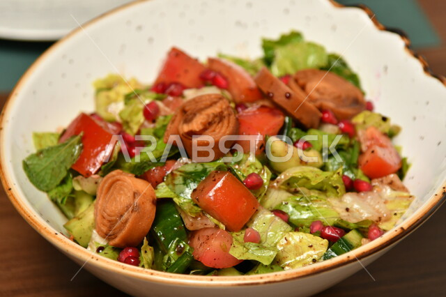 وعاء مليء بقطع الخضراوات ولفائف الخبز المحمص، أطباق شعبية تقليدية في السعودية، طبق من الفتوش والمقبلات الشهية، مطاعم للمأكولات الشرقية، الأساليب الفنية في تقديم الطعام