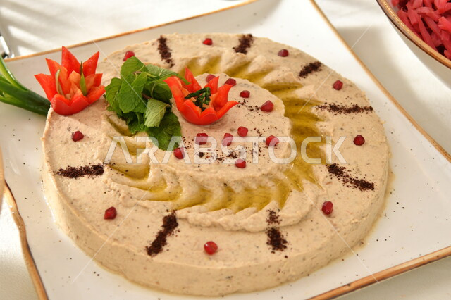 المقبلات النباتية الباردة اللذيذة، طبق من كريم الحمص اللذيذ المزين بالتوابل والخضراوات، مأكولات وأطباق شعبية تقليدية، وصفات طعام شرقية عربية سعودية، تزيين الطعام بأساليب فنية