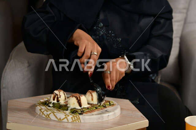 حلويات باردة لذيذة، طبق من الكريب الشهي المزين بكرات الآيس كريم، فتاة عربية خليجية سعودية تمسك الشوكة والسكين تقوم بتناول قطعة من الحلا، سكريات وأطعمة ذات سعرات حرارية عالية