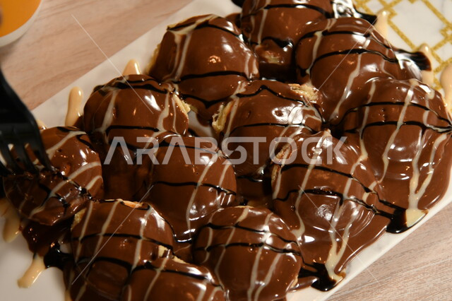 مقاهي وكافيهات في المملكة العربية السعودية، سكريات وأطعمة ذات سعرات حرارية عالية، صورة مقربة لطبق من بابلز الوافل المغمس بصوص الشوكولاته، حلا قهوة لذيذ