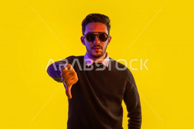 بورتريه لرجل سعودي خليجي غاضب و عابس بإيماءات وجه و يدين مختلفة  ، تعابير وجه و يدين مختلفة ، خلفية ملونة