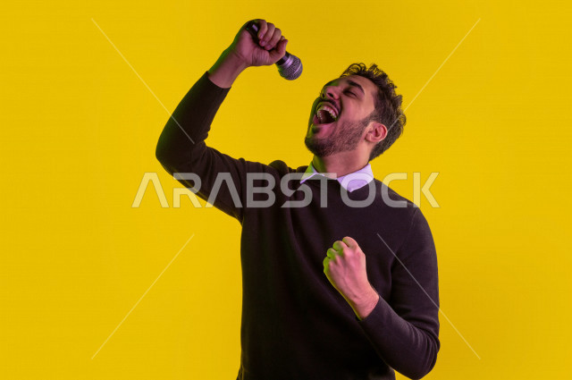 Portrait of a happy Saudi Gulf man, carrying a microphone and singing, face and hand gestures indicating happiness and enjoyment, singing talent, colorful background