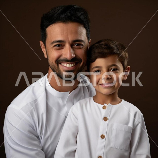 ارتداء الملابس الجديدة، بهجه وفرحة الأطفال بالعيد، الاهتمام والاعتناء بالابناء، مفهوم الأبوة و الترابط الأسري، الاحتفال بالأعياد الإسلامية السعيدة، بورتريه مقرب لرجل عربي خليجي سعودي يرتدي الثوب التقليدي مع ابنه ينظران إلى الكاميرا بايماءات السرور، خلفية سوداء