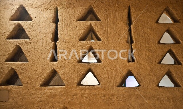Old popular heritage buildings  in  old Diriyah in the city of Riyadh, a close-up picture of windows with geometric shapes on a clay wall, ancient architectural art in the Kingdom of Saudi Arabia